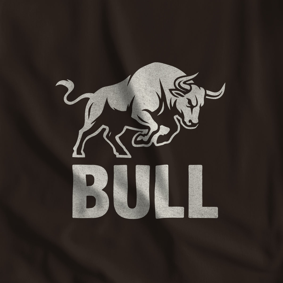 Close-up of the BULL print, a charging bull in off-white ink over block lettering on brown fabric #color_Brown
