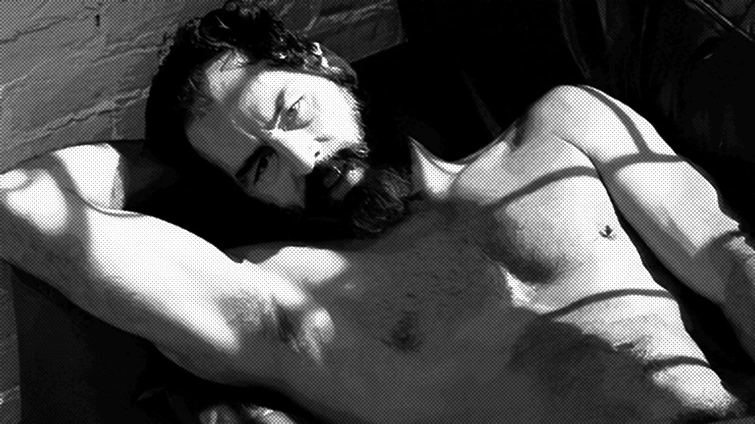 Richard Locke reclining shirtless with one arm behind his head, dark hair and mustache, in a high-contrast halftone treatment of a vintage promotional photograph.