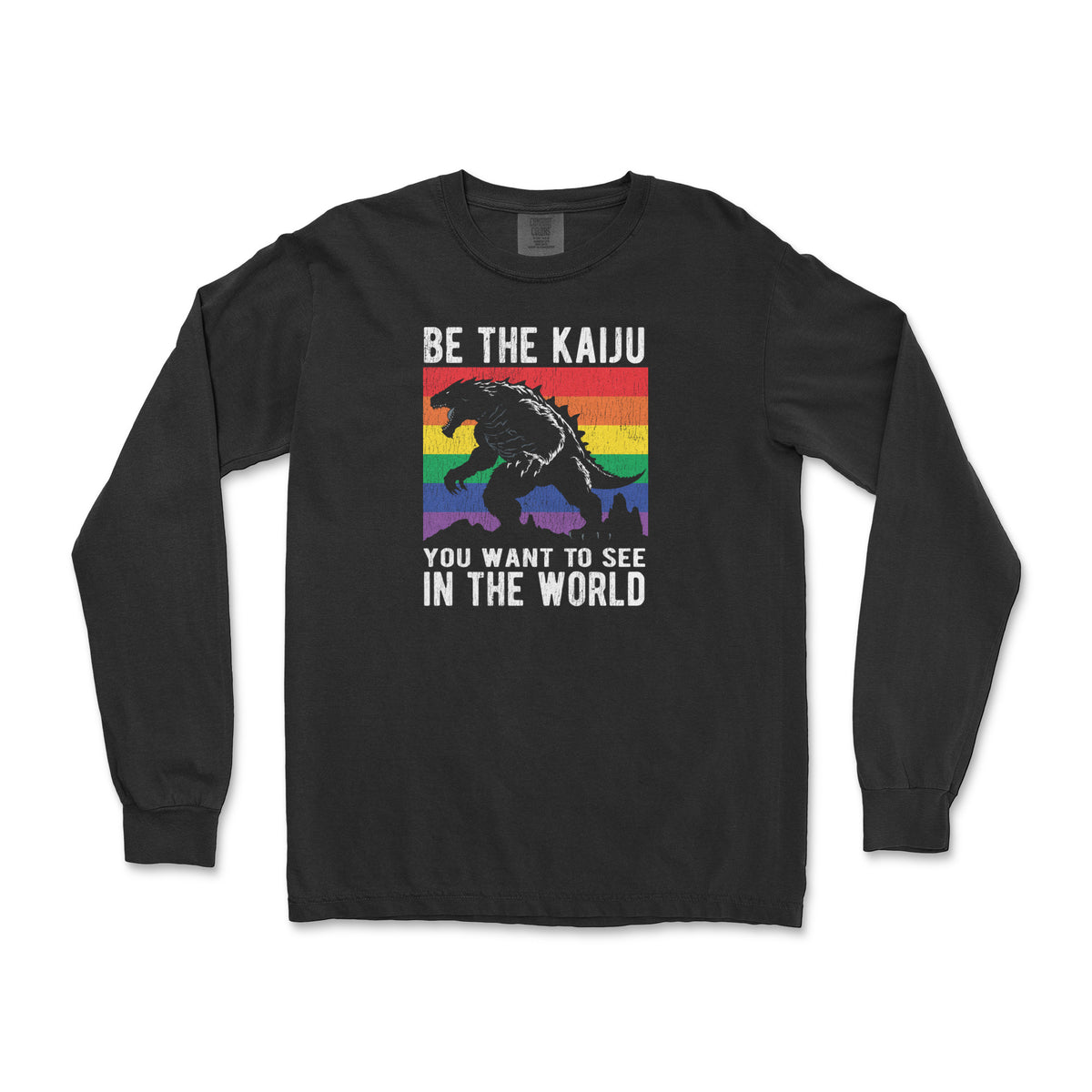 "Be the Kaiju You Want to See in the World" kaiju over a rainbow flag on a black long sleeve shirt, flat lay #color_Black