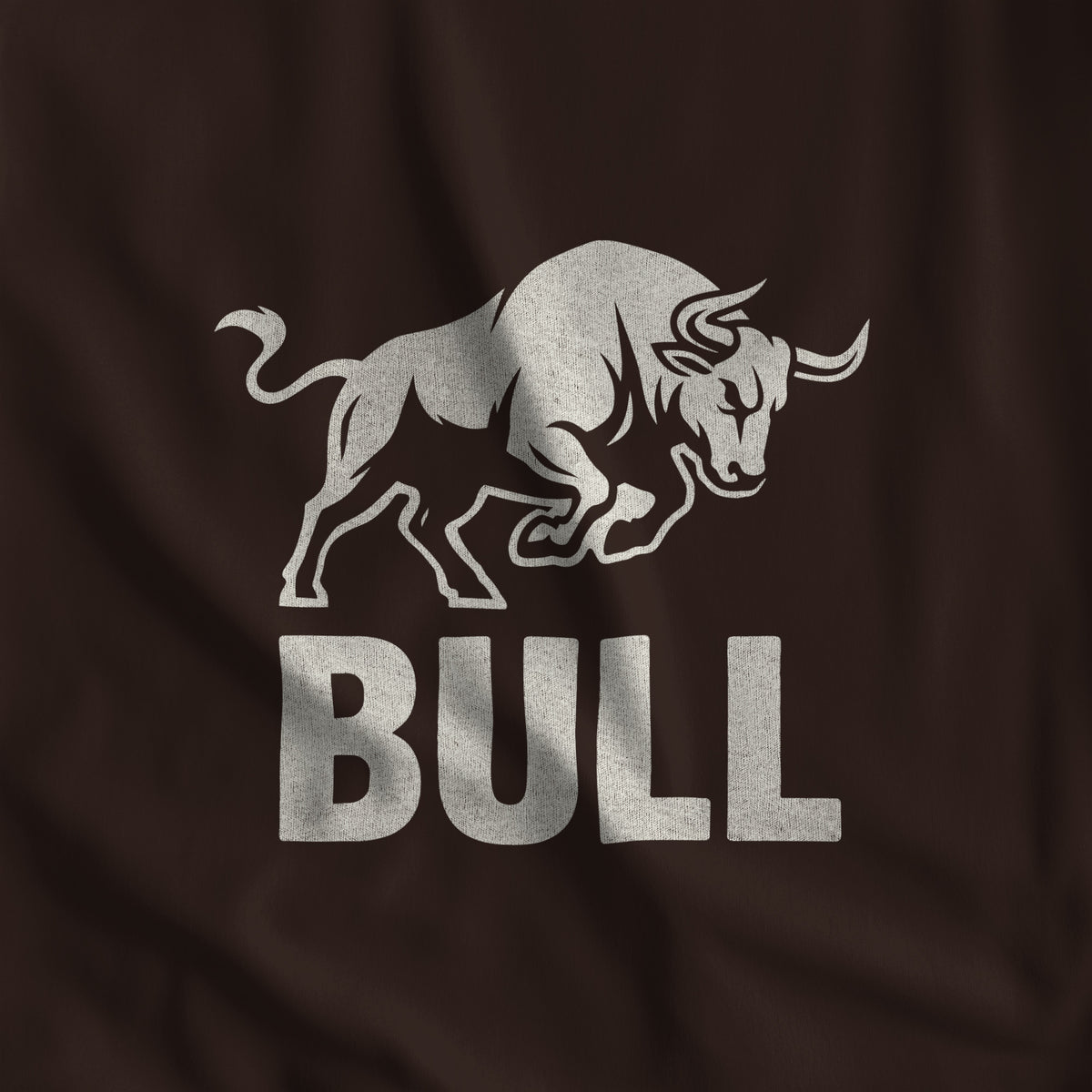 Close-up of the BULL print, a charging bull in off-white ink over block lettering on dark chocolate fabric #color_Dark Chocolate